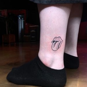 Get a unique tattoo featuring tongue and lips motif with Rolling Stones logo, expertly done by artist Liam Collins.