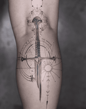 Experience the sharp precision of this geometric realism sword tattoo on your lower leg, expertly crafted by Kayla.