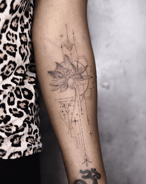 Beautiful forearm tattoo featuring a geometric and micro-realism style flower, expertly done by Kayla.