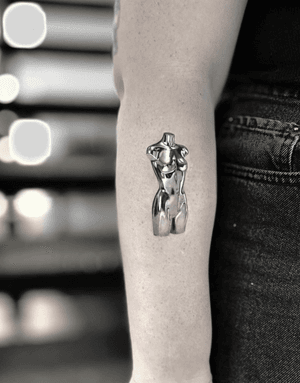 Emre's micro_realism tattoo features a stunning silver woman's torso design on the arm.