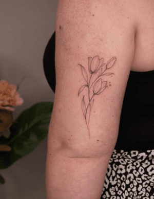 Get a delicate and intricate flower design on your upper arm by tattoo artist Lucas Scardua. Perfect for a subtle yet beautiful body art.