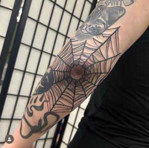 Embrace the artistry of an illustrative spiderweb design, expertly crafted by tattoo artist Katy Sarsfield.
