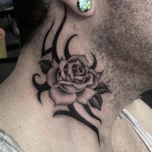 Experience the unique fusion of illustrative and tribal styles with this striking rose tattoo by Gianluca Fusco.