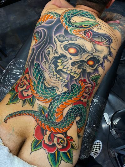 Get inked with a striking traditional tattoo featuring a snake and grim reaper design by Gianluca Fusco. Embrace the dark side with this bold and timeless masterpiece.