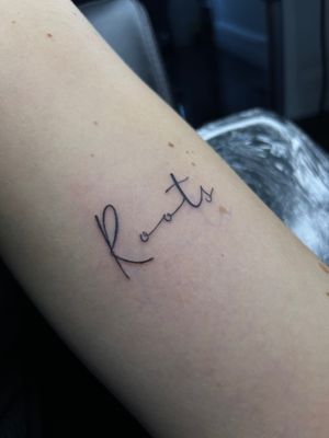 Express yourself with this small lettering tattoo on your arm, created by the talented artist Claudia Whiteheart. A subtle and timeless design.