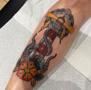 Capture the timeless beauty of a lighthouse with this traditional tattoo by Katy Sarsfield. Perfect for your shin!
