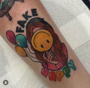 Vibrant arm tattoo by Katy Sarsfield featuring a smiling woman surrounded by colorful balloons in a neo-traditional style.