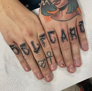Get sleek and stylish lettering tattoo on your finger by the talented artist Katy Sarsfield. Perfect for a subtle touch of personal expression.
