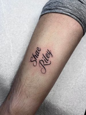 Get a personalized small lettering tattoo by Claudia Whiteheart on your arm. Express yourself with style!