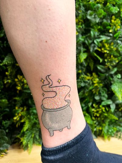 Embrace your inner magical kawaii side with this adorable witch cauldron tattoo by Rachel Angharad, complete with glitter accents.