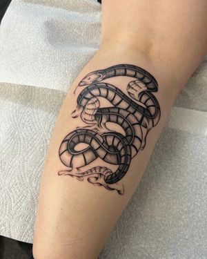 Unleash your wild side with this intricate snake tattoo. Expertly crafted in dotwork style by artist Jack Howard.