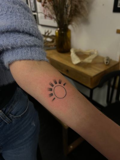 A beautiful dotwork and fine line minimalist sun tattoo, perfectly placed on your arm by talented artist Jack Howard.