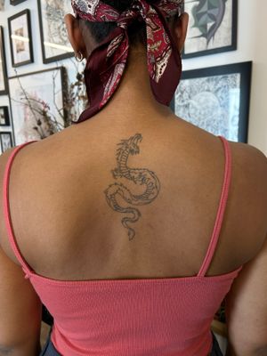 Get inked with a fierce Japanese dragon by Jack Howard on your upper back for a stunning and powerful tattoo design.
