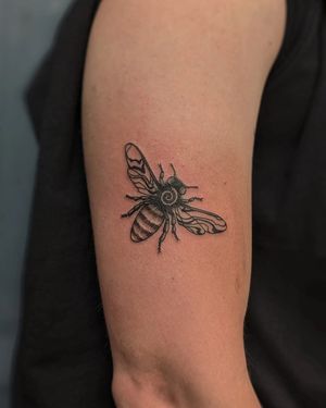 Express your connection to nature with this intricate blackwork, dotwork, hand_poke, and illustrative bee tattoo created by the talented artists at Alien Ink.