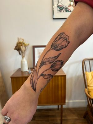 Capture the beauty of nature with this stunning illustrative tulip tattoo done by the talented artist Jack Howard.