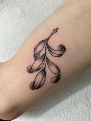 Beautiful floral arm tattoo featuring delicate olive leaves by Jack Howard.