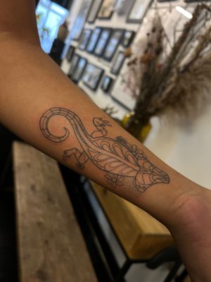 Express your uniqueness with a stunning fine line chameleon tattoo on your arm, expertly crafted by the talented artist Jack Howard.