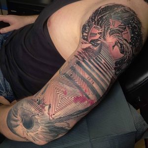 A stunning black and gray tattoo featuring a unique pattern with elements of a clock, stairway, and eye. Located in Chicago, US.