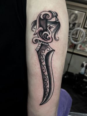 An impressive traditional tattoo of a knife on the forearm by talented artist Barney Coles.