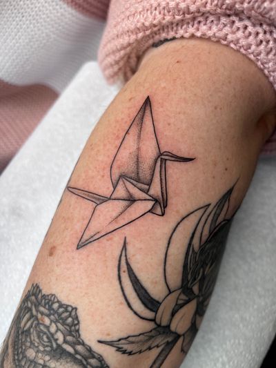 Experience the elegance of black and gray origami on your arm with this stunning tattoo by the talented artist Claudia Whiteheart.