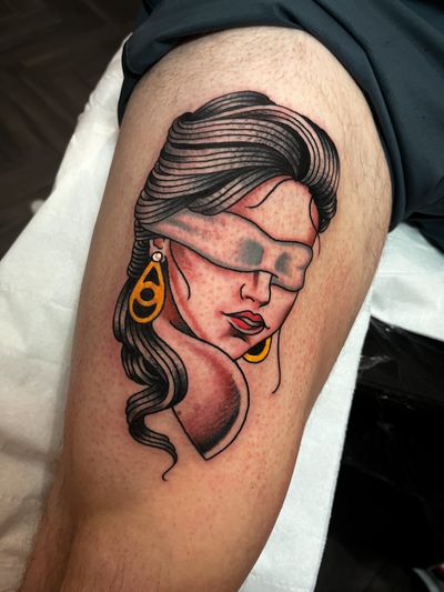 Barney Coles beautifully combines chicano and neo-traditional styles in this captivating tattoo of a blindfolded lady on the thigh.