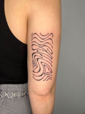 Get an illustrative tattoo by Dan Bramfitt featuring fluid, wavy lines creating a mesmerizing abstract design.