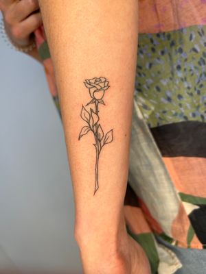 Bold and edgy arm tattoo featuring a stunning rose design by the talented artist Danyul.