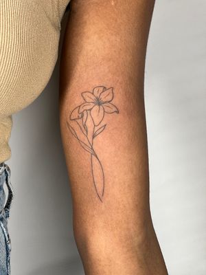 A beautiful flower motif tattoo on the upper arm, done in the unique ignorant style by tattoo artist Dan Bramfitt (Danyul).
