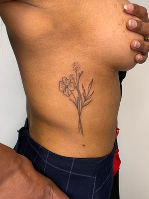 Beautiful flower motif tattoo by Dan Bramfitt, aka Danyul, on the ribs, showcasing a unique ignorant style.