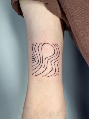 Hand-poked tattoo by Dan Bramfitt featuring intricate wavy lines for a unique and stylish design.