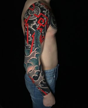 Dive into the world of Japanese tattoos with this impressive sleeve featuring a fierce shark and intricate traditional patterns, expertly done by Andrea Furci.