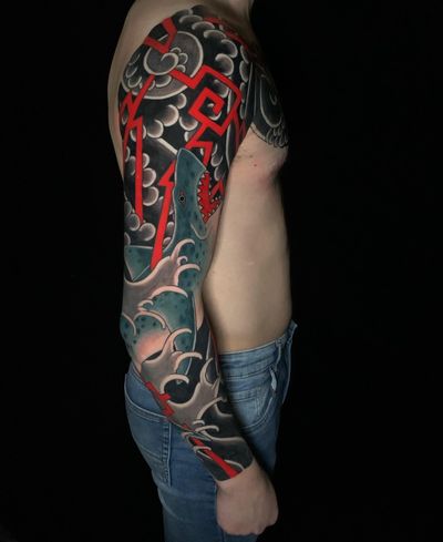 Dive into the world of Japanese tattoos with this impressive sleeve featuring a fierce shark and intricate traditional patterns, expertly done by Andrea Furci.