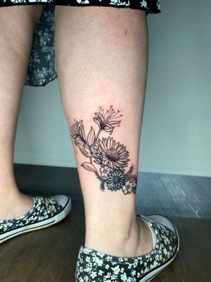 Get a delicate and intricate lily flower tattoo done in fine line illustrative style by the talented artist Liam Collins.