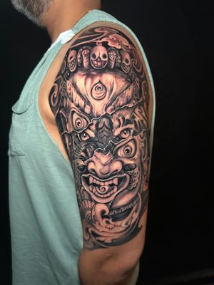 Stunning black and gray tattoo by Avi, featuring a fierce tiger and powerful mahakala deity.