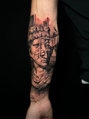Experience the beauty of black and gray with this detailed and intricate geometric statue tattoo done by the talented artist Avi.