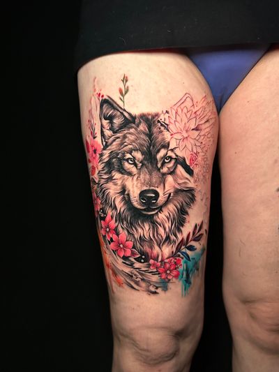 Capture the beauty of nature with this stunning tattoo featuring a wolf and lily, expertly crafted by Avi. Perfect for nature lovers.