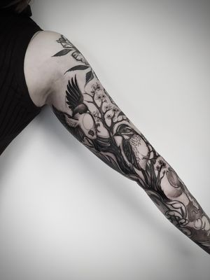 Unique blackwork and illustrative tattoo of a bird perched on a sakura tree branch, designed by talented artist Helena Velazquez.