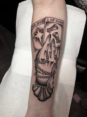 Experience the mystical allure of a traditional illustrative tattoo featuring a tarot card, hand, and beads, crafted by Barney Coles.
