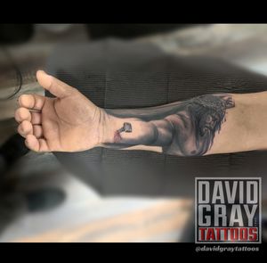 Realistic Jesus tattoo nailed through arm