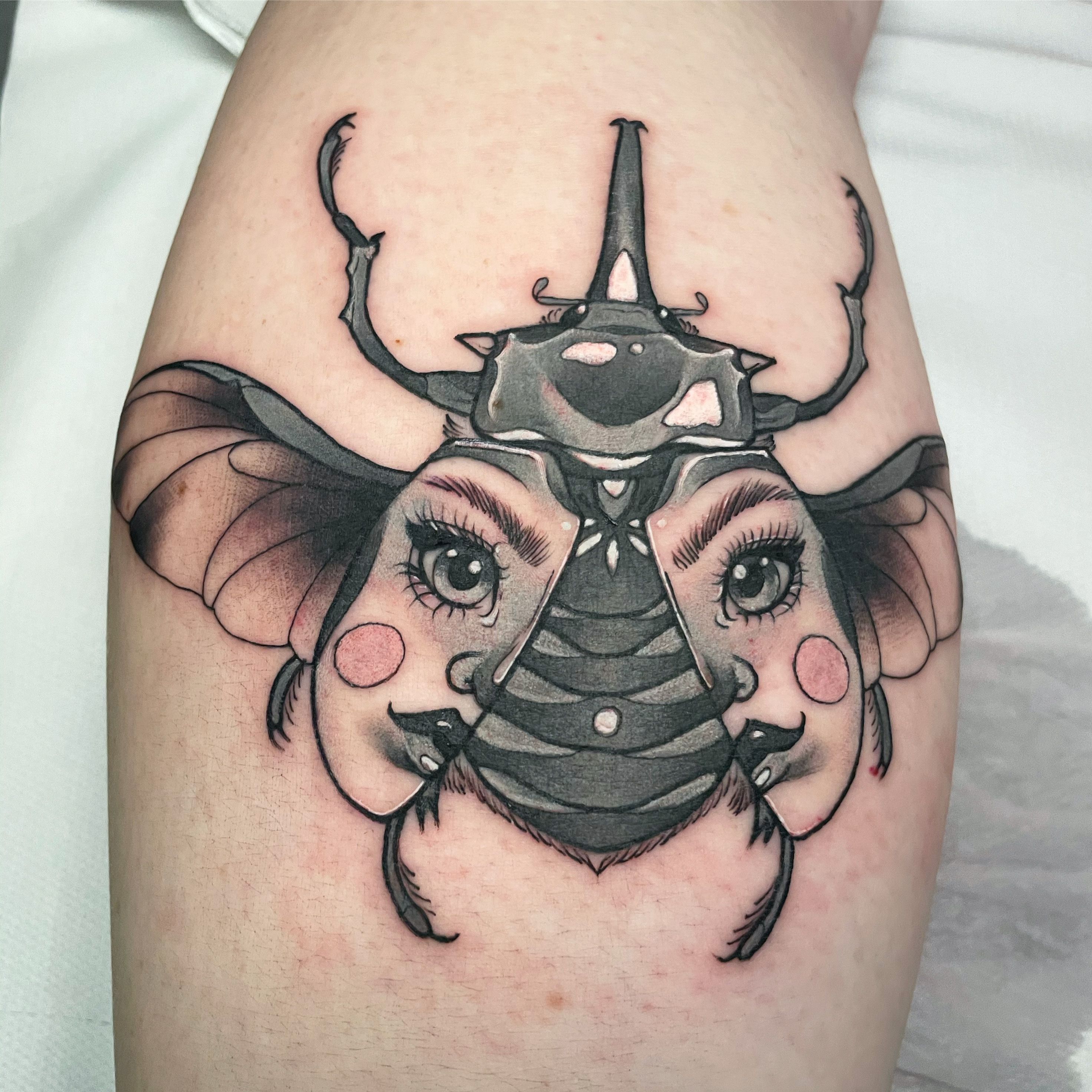 Bettle tattoo located on the upper arm.