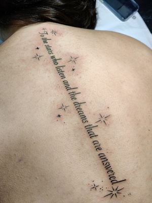 Small lettering tattoo by Mary Shalla featuring the quote 'To the stars who listen and the dreams that are answered'.