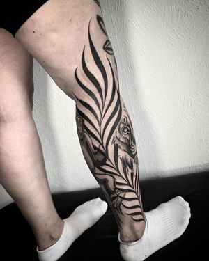 Experience the fierce energy of a monkey and tiger in this striking blackwork tattoo by Helena Velazquez.