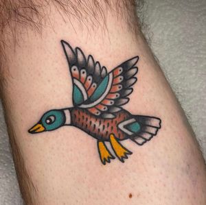 Get inked with a classic traditional duck design on your lower leg by the talented artist Sam Young. Embrace the timeless beauty of this unique tattoo motif.