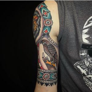 Get a stunning traditional style tattoo of an eagle and hawk designed by the talented artist Sam Young.