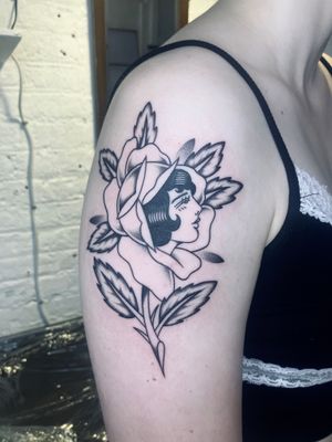 Capture the beauty of a traditional rose with a woman's silhouette in this stunning tattoo by Rachel Arfin.
