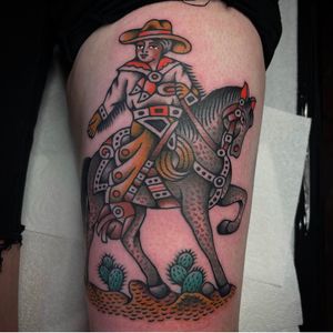 Get inked with a traditional cowboy design by tattoo artist Sam Young on your thigh. Ride into the sunset in style!