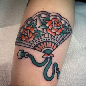 Check out this vibrant traditional fan tattoo on the lower arm, expertly done by talented artist Sam Young. Perfect for those who appreciate classic tattoo motifs.