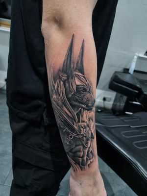 Capture the mystique of ancient Egypt with this stunning black and gray Anubis tattoo by the talented artist Joni Smith.