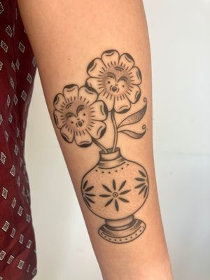 Experience the beauty of dotwork and traditional styles with this stunning flower vase tattoo by the talented artist Rachel Arfin.