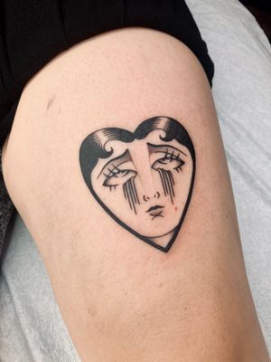 Get inked by Rachel Arfin with this emotive tattoo featuring a heart and sad face, in a classic traditional style.